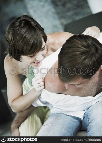 High angle view of a young woman pulling a young man&acute;s shirt