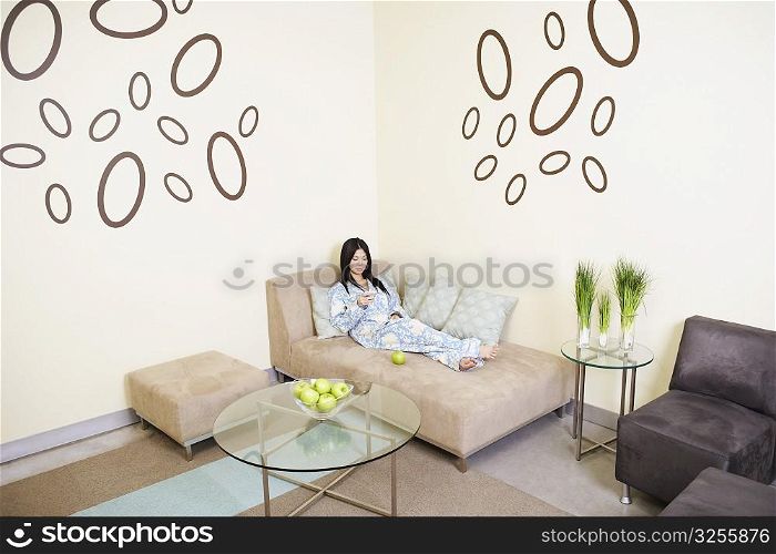 High angle view of a young woman reclining on a couch
