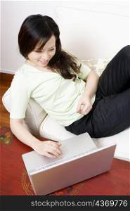 High angle view of a young woman shopping online and holding a credit card