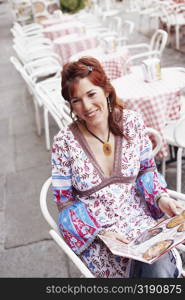 High angle view of a young woman sitting in a restaurant and holding a menu