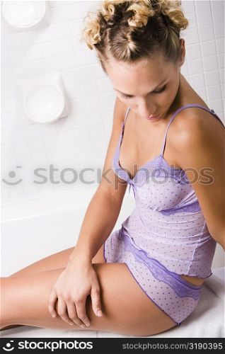 High angle view of a young woman sitting in the bathroom