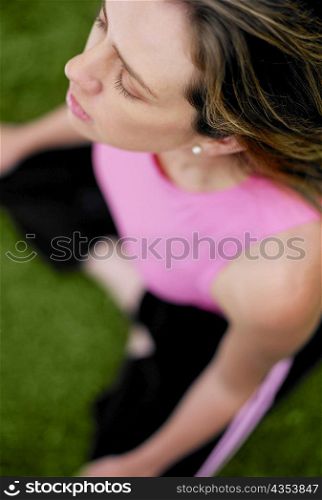High angle view of a young woman sitting in the lotus position