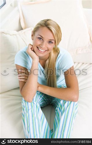 High angle view of a young woman sitting on a bed