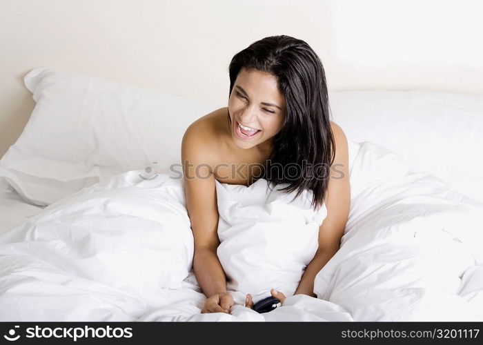 High angle view of a young woman sitting on a bed