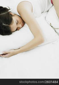 High angle view of a young woman sleeping and hugging a pillow