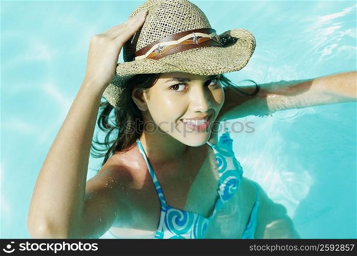 High angle view of a young woman swimming in a pool and smiling