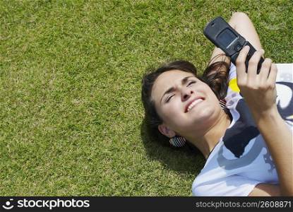 High angle view of a young woman text messaging and smiling