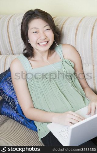 High angle view of a young woman using a laptop and clenching teeth