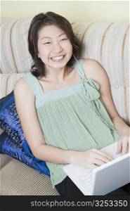 High angle view of a young woman using a laptop and clenching teeth