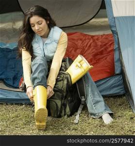 High angle view of a young woman wearing galoshes in a tent