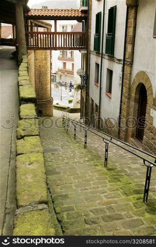 High angle view of an empty alleyway leading to the street, Spain