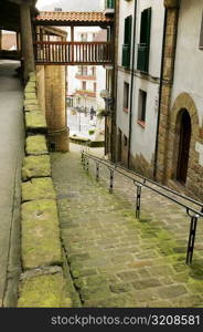 High angle view of an empty alleyway leading to the street, Spain