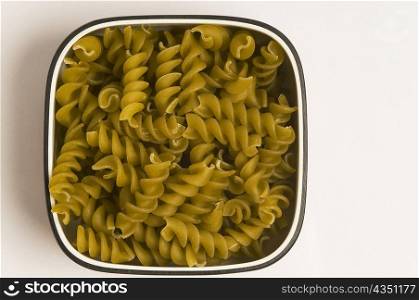 High angle view of bowl of raw fusilli pasta