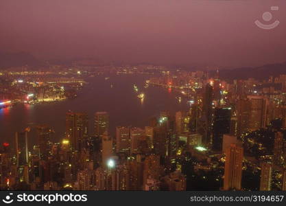 High angle view of buildings in a city lit up at night, Hong Kong, China