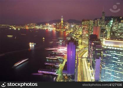High angle view of buildings in a city lit up at night, Hong Kong, China