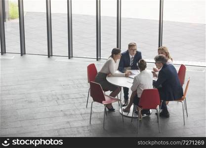 High angle view of business colleagues planning while sitting at office during meeting