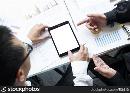 High angle view of business colleagues using blank screen digital tablet at desk in office.