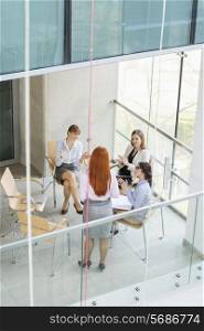 High angle view of businesswoman giving presentation to colleagues in office