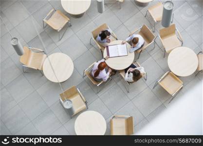 High angle view of businesswomen doing paperwork in office canteen