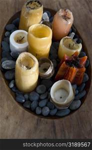 High angle view of candles and pebbles in a wooden tray