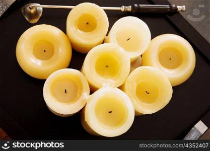 High angle view of candles with a bell in a tray