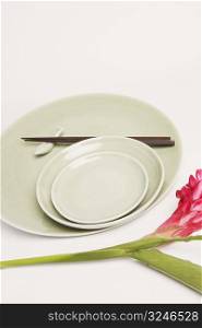 High angle view of chopsticks and plates with a flower