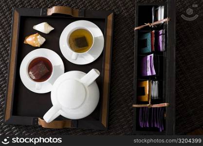 High angle view of cups of herbal tea with a teapot on a serving tray