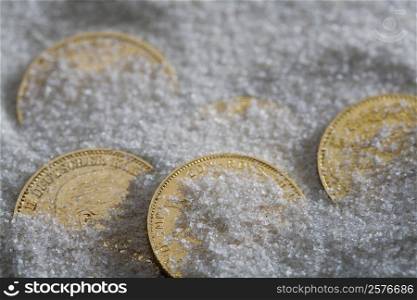 High angle view of five coins in salt