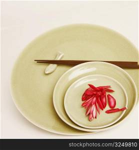 High angle view of flower petals and chopsticks in a plate