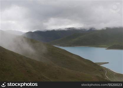 High angle view of foggy mountains with Yamdrok Lake, Nagarze, Shannan, Tibet, China