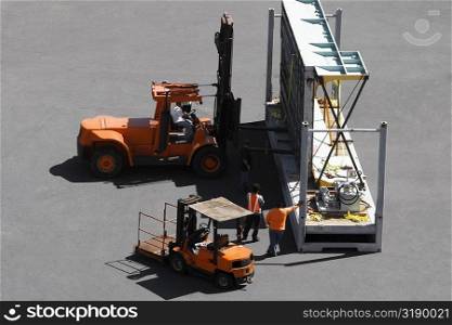 High angle view of forklifts and workers at a commercial dock
