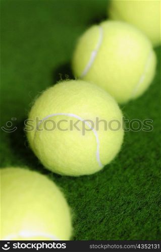 High angle view of four tennis balls in a row