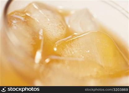 High angle view of ice cubes in a glass of orange juice