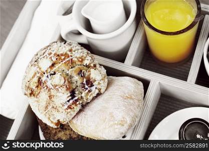 High angle view of muffins and a glass of orange juice in a breakfast tray