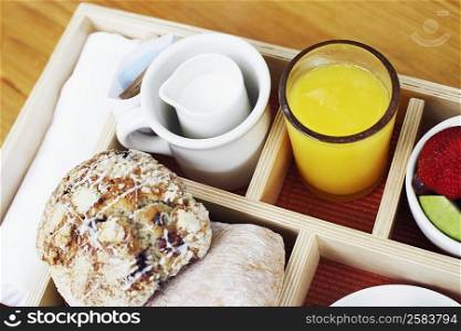High angle view of muffins and a glass of orange juice in a breakfast tray
