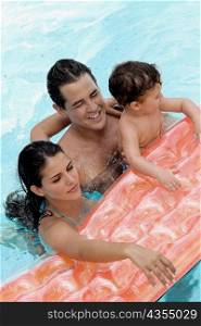 High angle view of parents with their son in a swimming pool