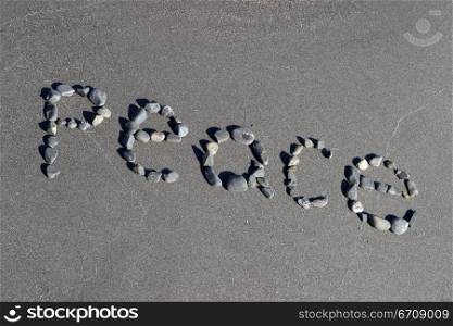 High angle view of peace written with pebbles