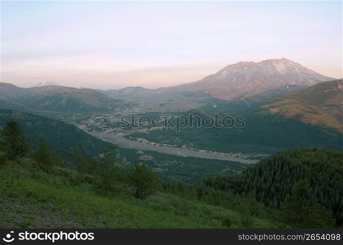 High angle view of remote river valley, rolling landscapes and mountains in the distance