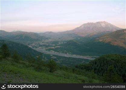 High angle view of remote river valley, rolling landscapes and mountains in the distance