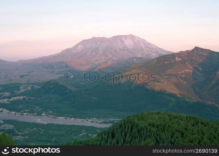 High angle view of remote river valley, rolling landscapes and mountains in the distance