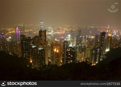 High angle view of skyscrapers lit up at night in a city, Victoria Harbor, Hong Kong Island, Hong Kong, China
