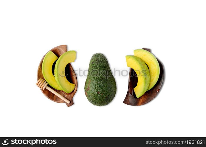 High angle view of slicing avocado on wood dish on white background.