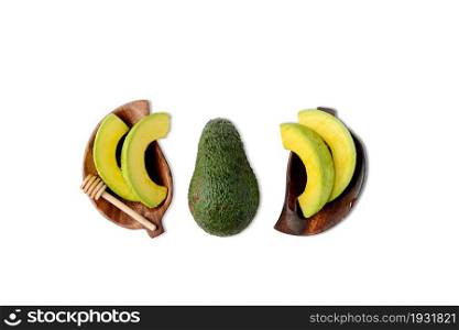 High angle view of slicing avocado on wood dish on white background.