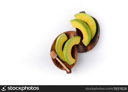 High angle view of slicing avocado on wood dish on white background.