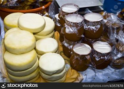 High angle view of stacks of cheese with tofu jars at a market stall, Zacatecas State, Mexico