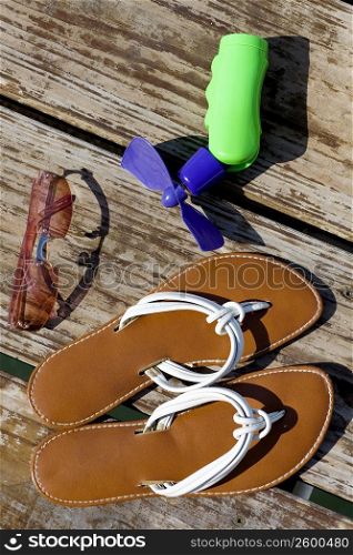High angle view of sunglasses with slippers