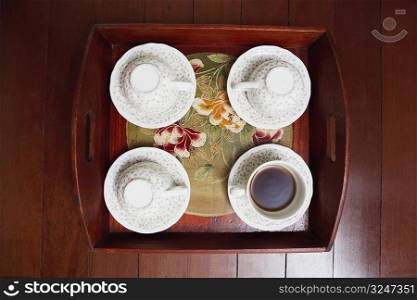 High angle view of tea cups with a tray on a hardwood floor