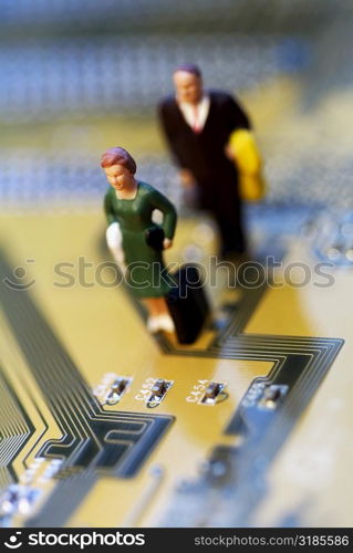 High angle view of the figurine of a woman and a man on a circuit board