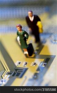 High angle view of the figurine of a woman and a man on a circuit board