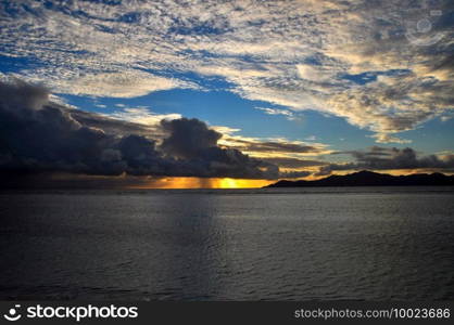 High angle view of the sunset over the island of Praslin with vibrant sky and the ocean with reflections